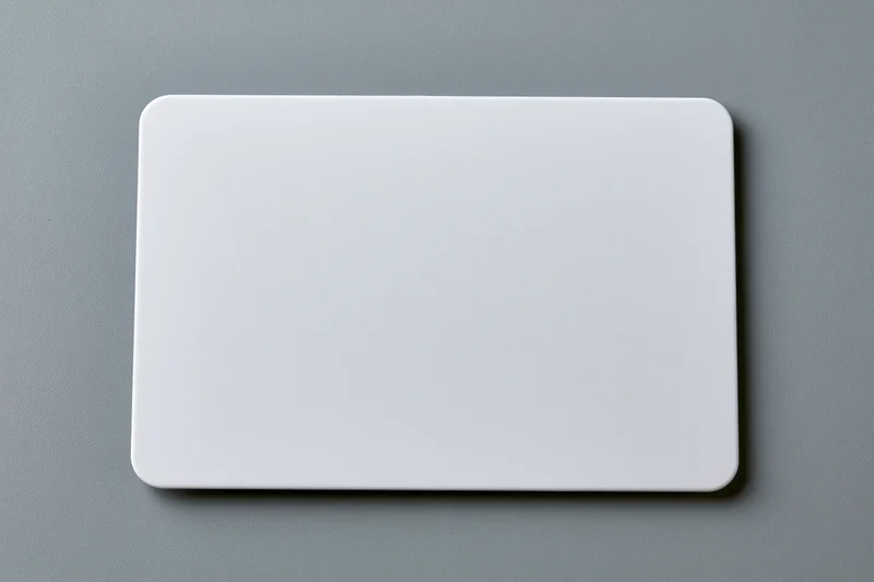 Blank white plastic card with rounded corners lying flat on gray surface