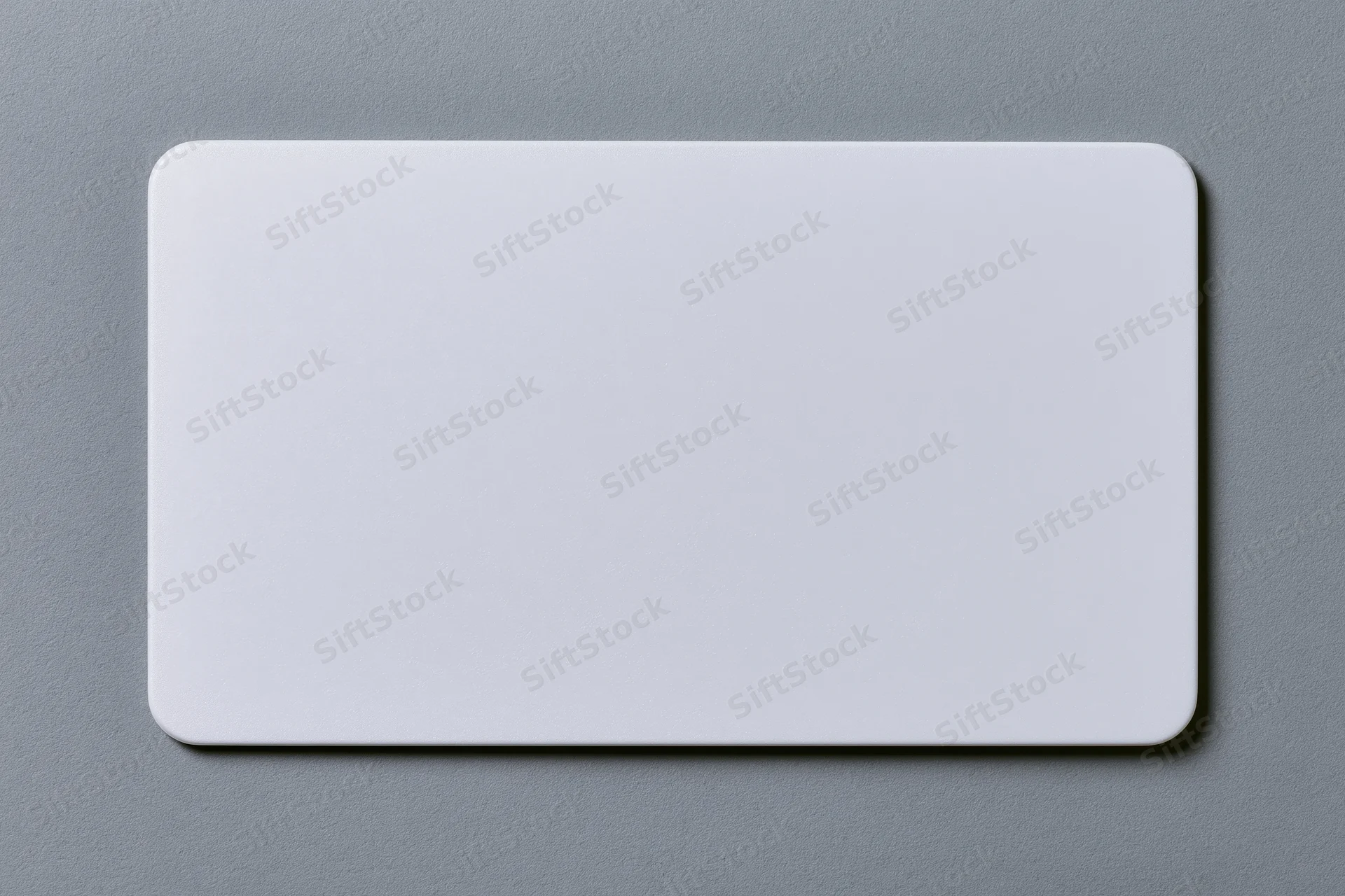 Blank white plastic card with rounded corners lying flat on gray surface