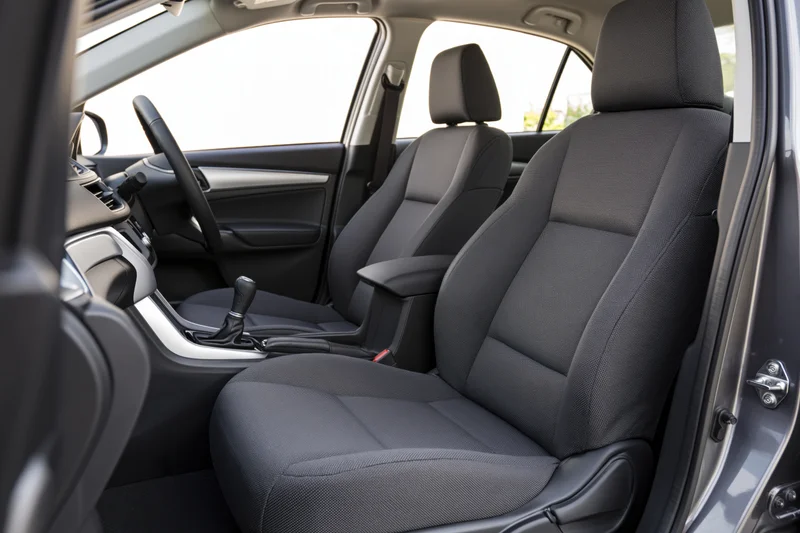 Front seats and dashboard of a car interior viewed from open passenger door