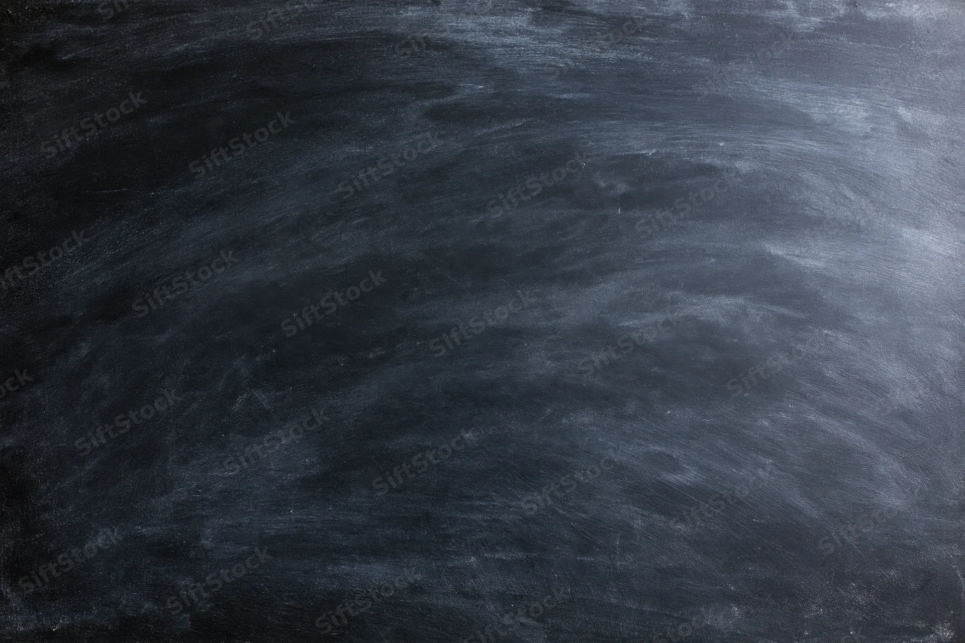 Close-up of a blank black chalkboard surface with smudged white chalk marks filling the frame