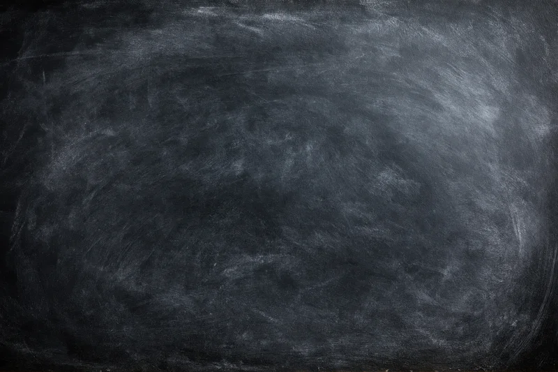 Close-up of a blank black chalkboard surface with smudged white residue, flat lay view