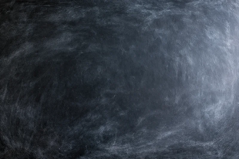 Close-up of a blank black chalkboard surface with smudged texture filling the frame