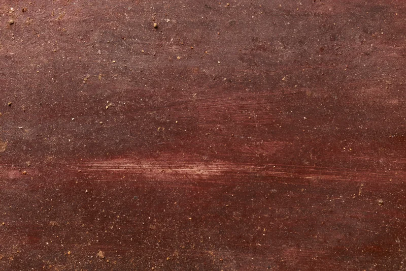 Close-up of an aged dark brown wooden surface with visible grain and wear marks