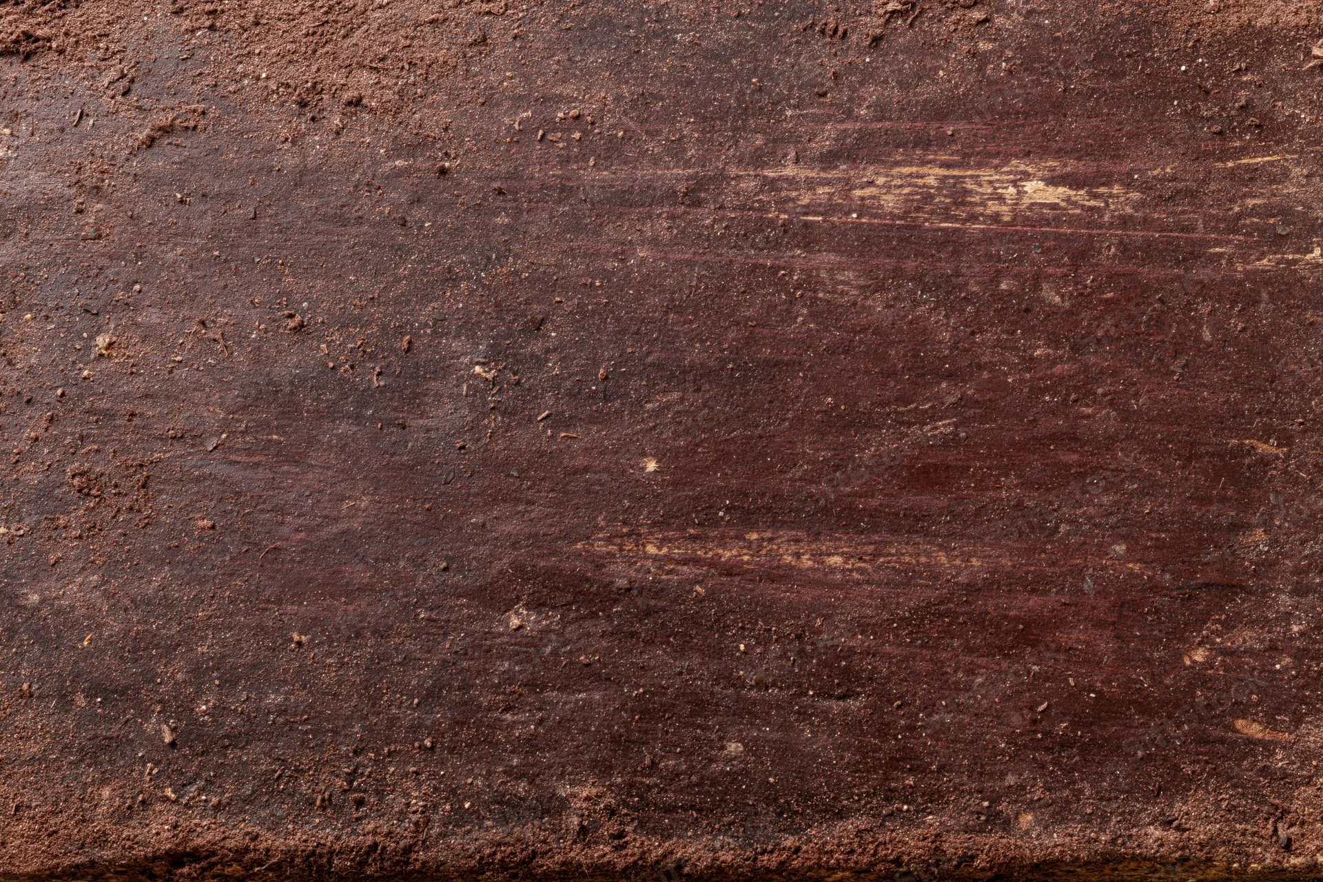 Close-up of aged dark brown wooden surface with visible grain and weathered texture