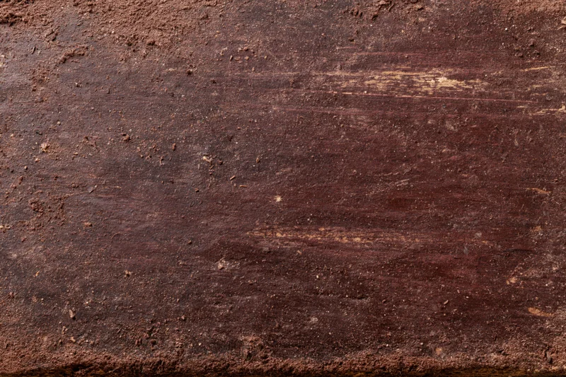 Close-up of aged dark brown wooden surface with visible grain and weathered texture