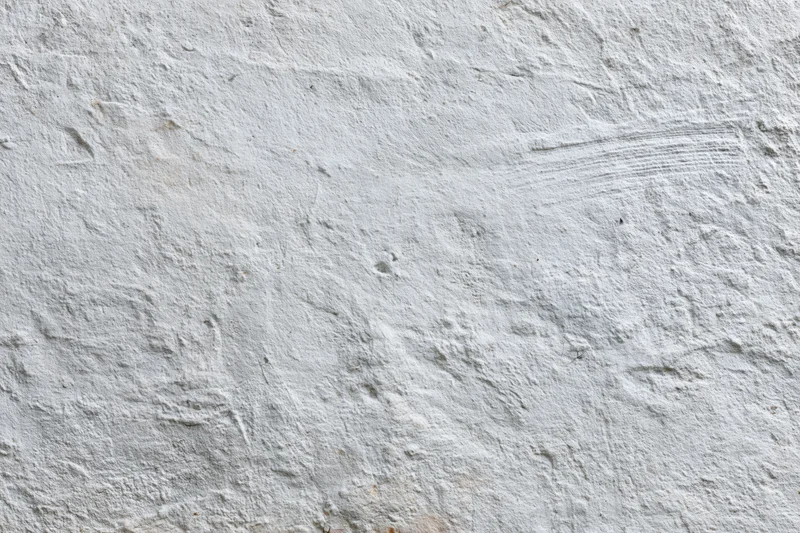 Close-up of a rough concrete wall surface with visible texture and imperfections