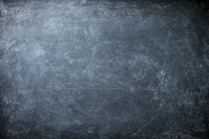Weathered dark chalkboard surface with scratches and smudges