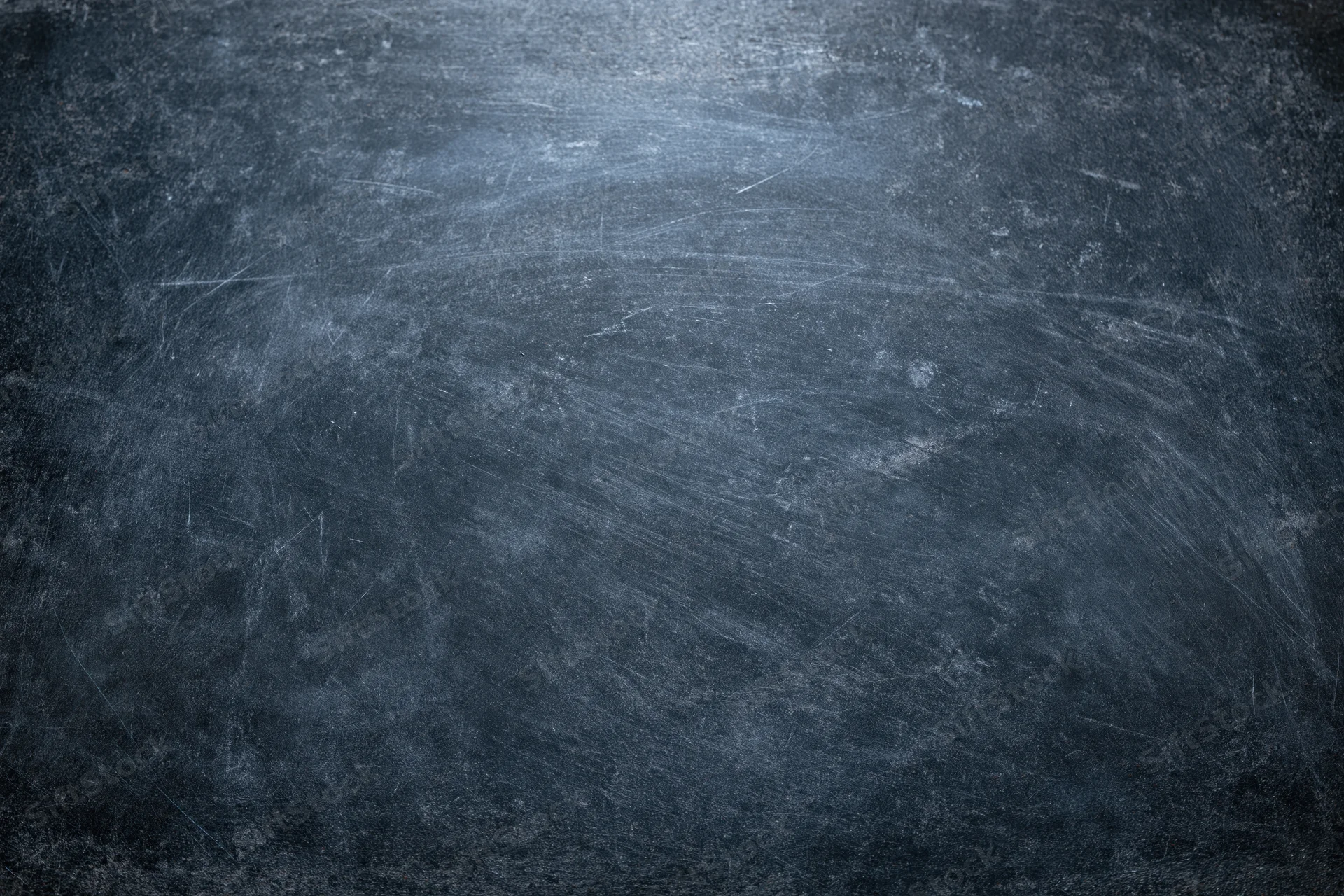 Close-up of a weathered dark chalkboard surface with scratches and smudges