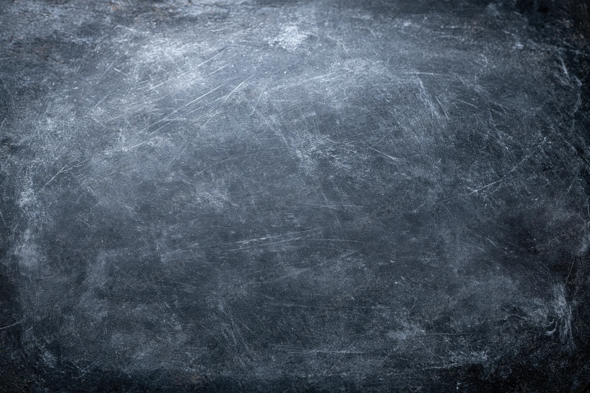 Close-up of a weathered dark chalkboard surface with scratches and smudges