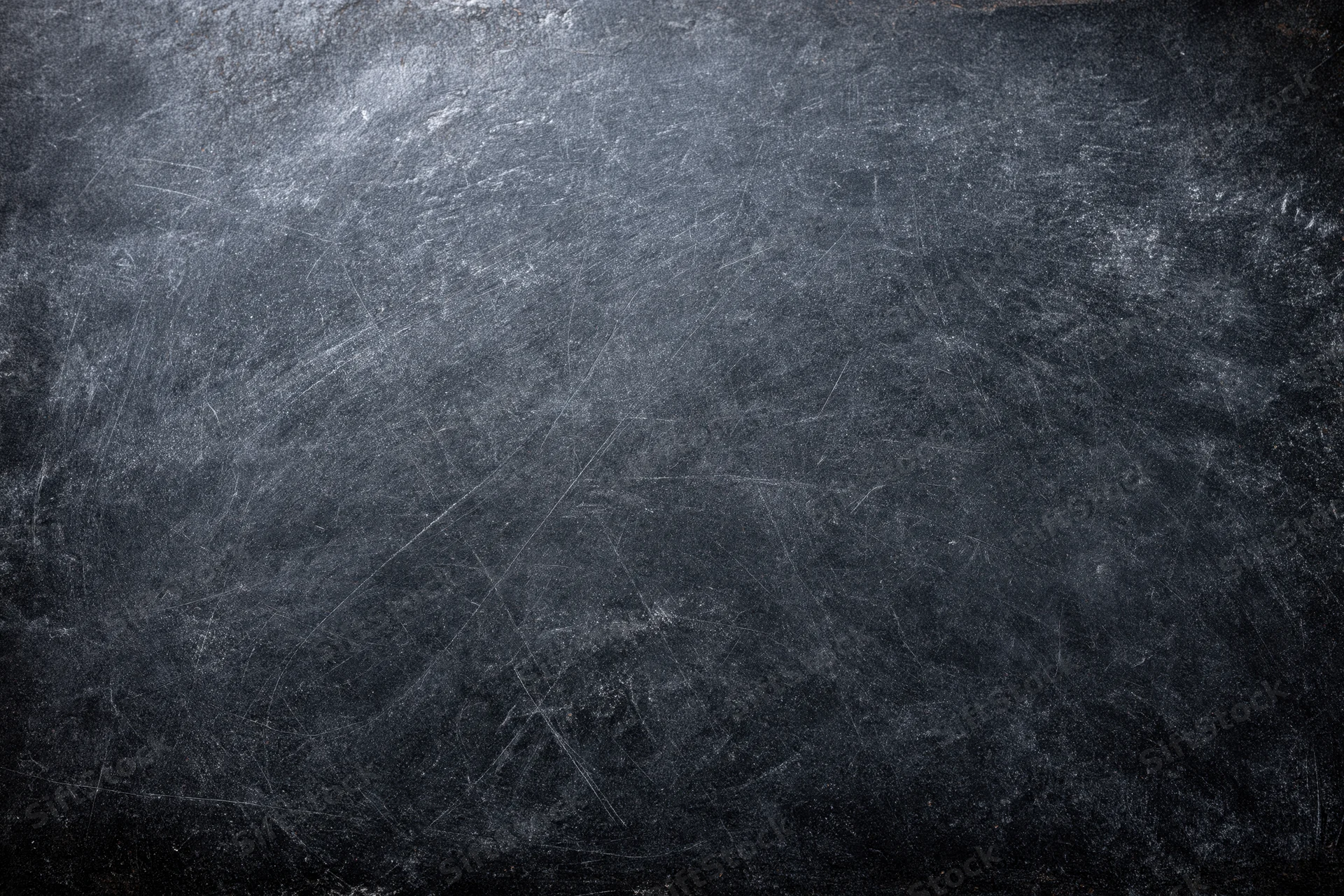 Close-up of a weathered dark chalkboard surface with scratches and smudges