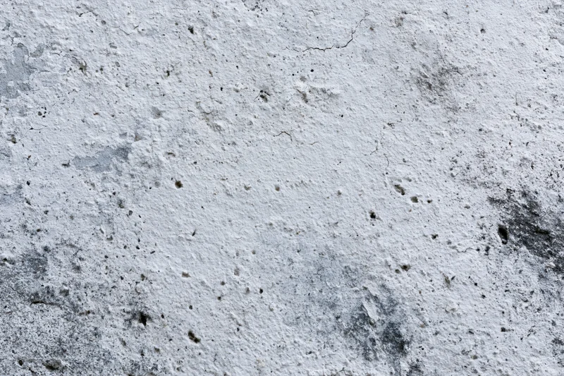 Close-up of a weathered concrete wall surface with cracks and stains