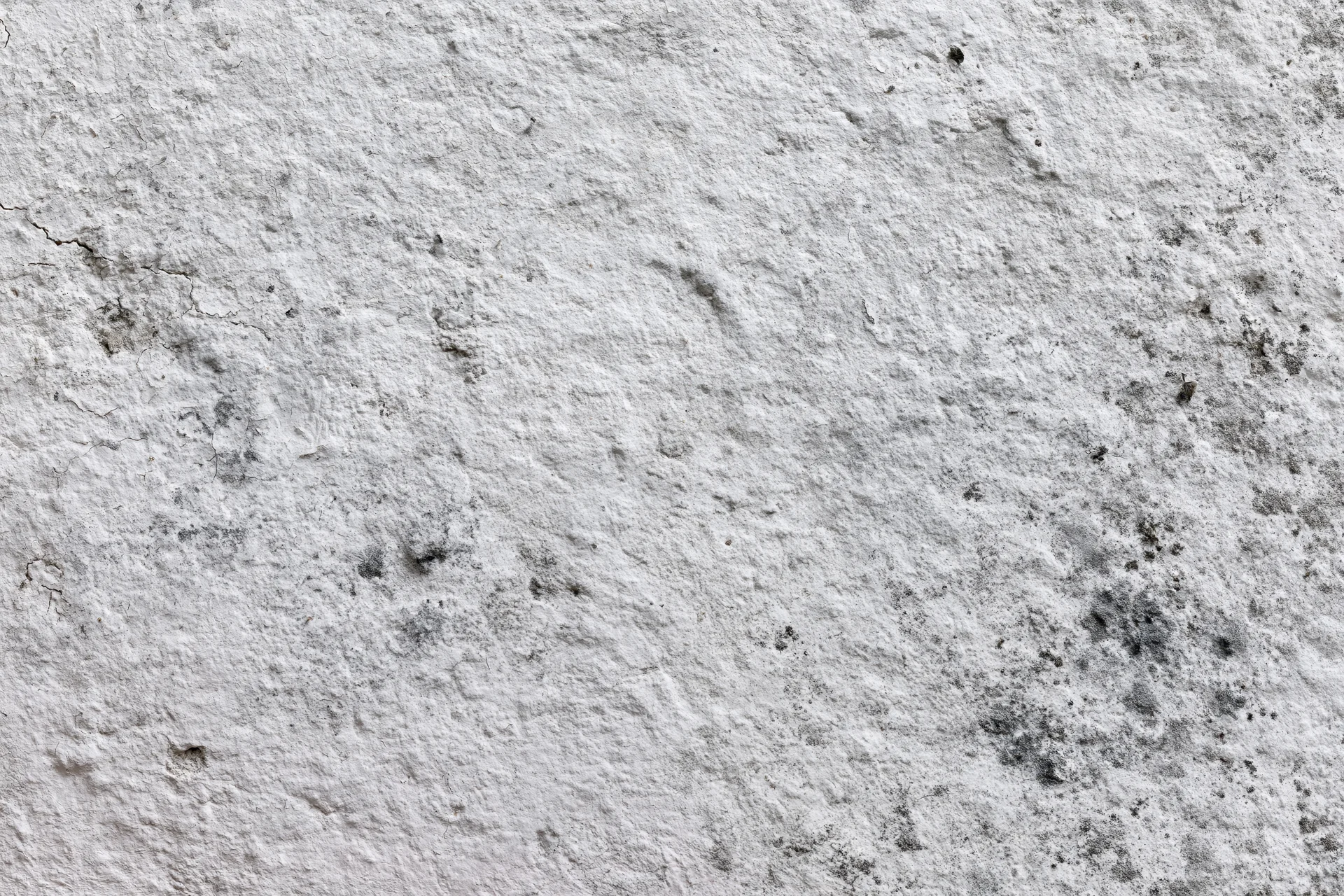 Close-up of weathered concrete wall surface with cracks and stains
