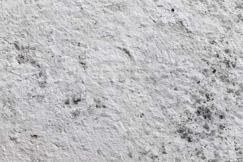 Close-up of weathered concrete wall surface with cracks and stains