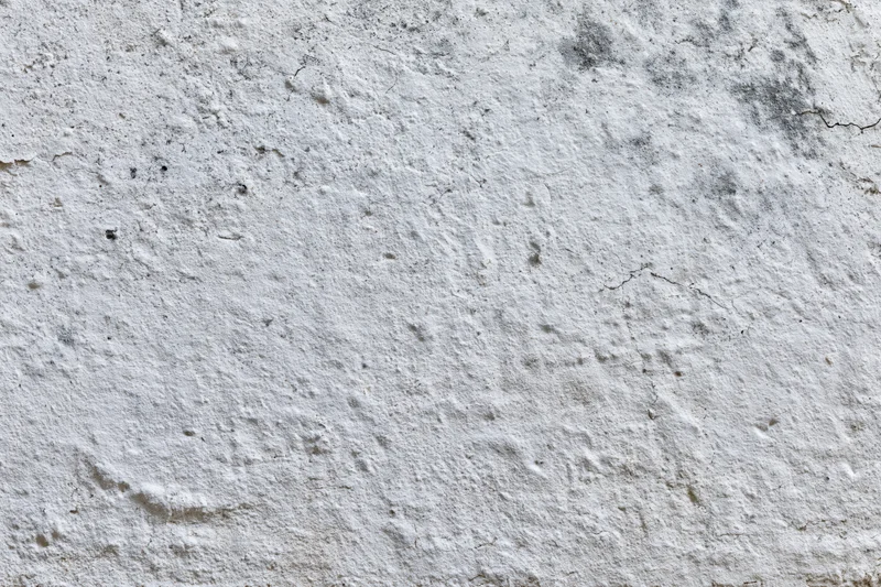 Close-up of a weathered concrete wall surface with cracks and texture