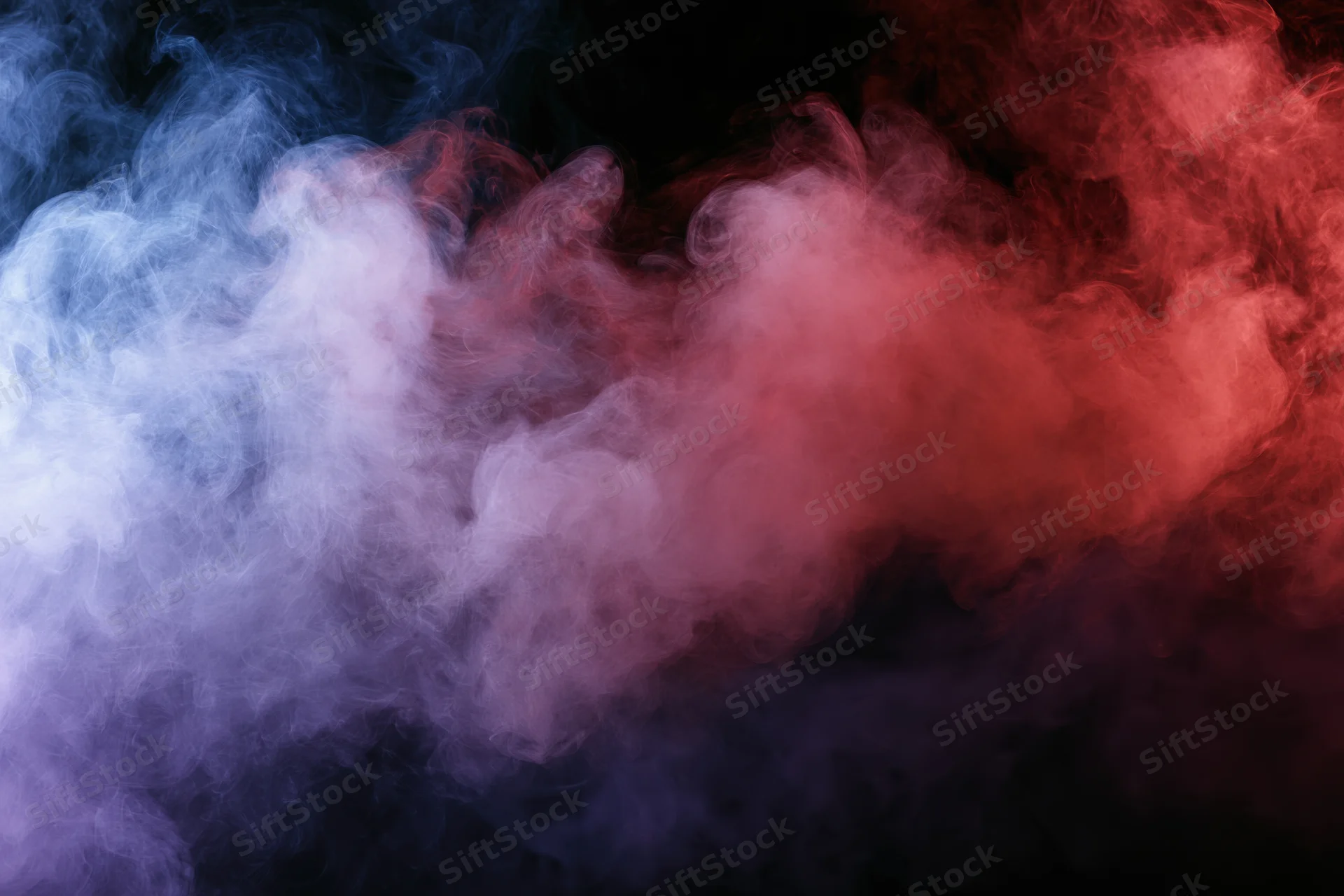 Swirling red and blue smoke drifting against a black background