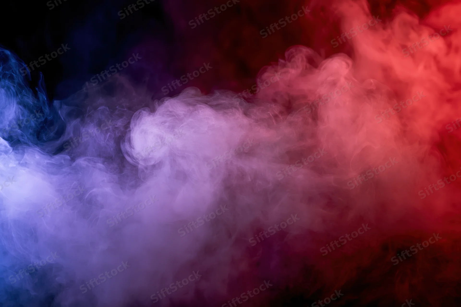 Colored smoke swirling and drifting against a black background