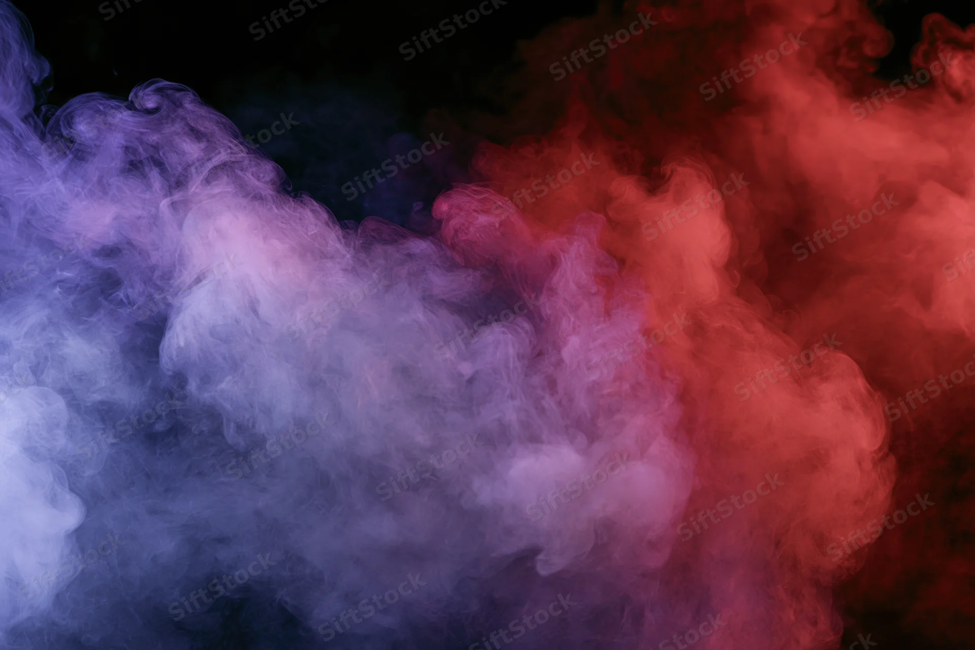 Colored smoke swirling and drifting against a black background