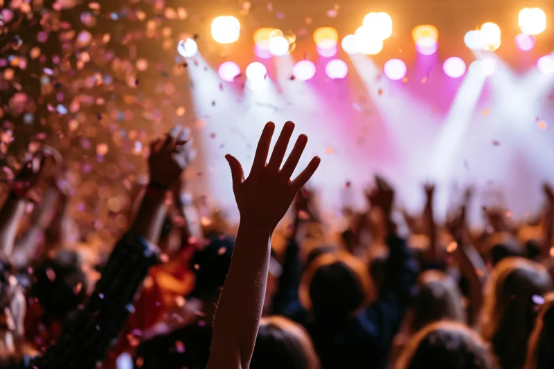 Crowd with arms raised toward stage during concert performance