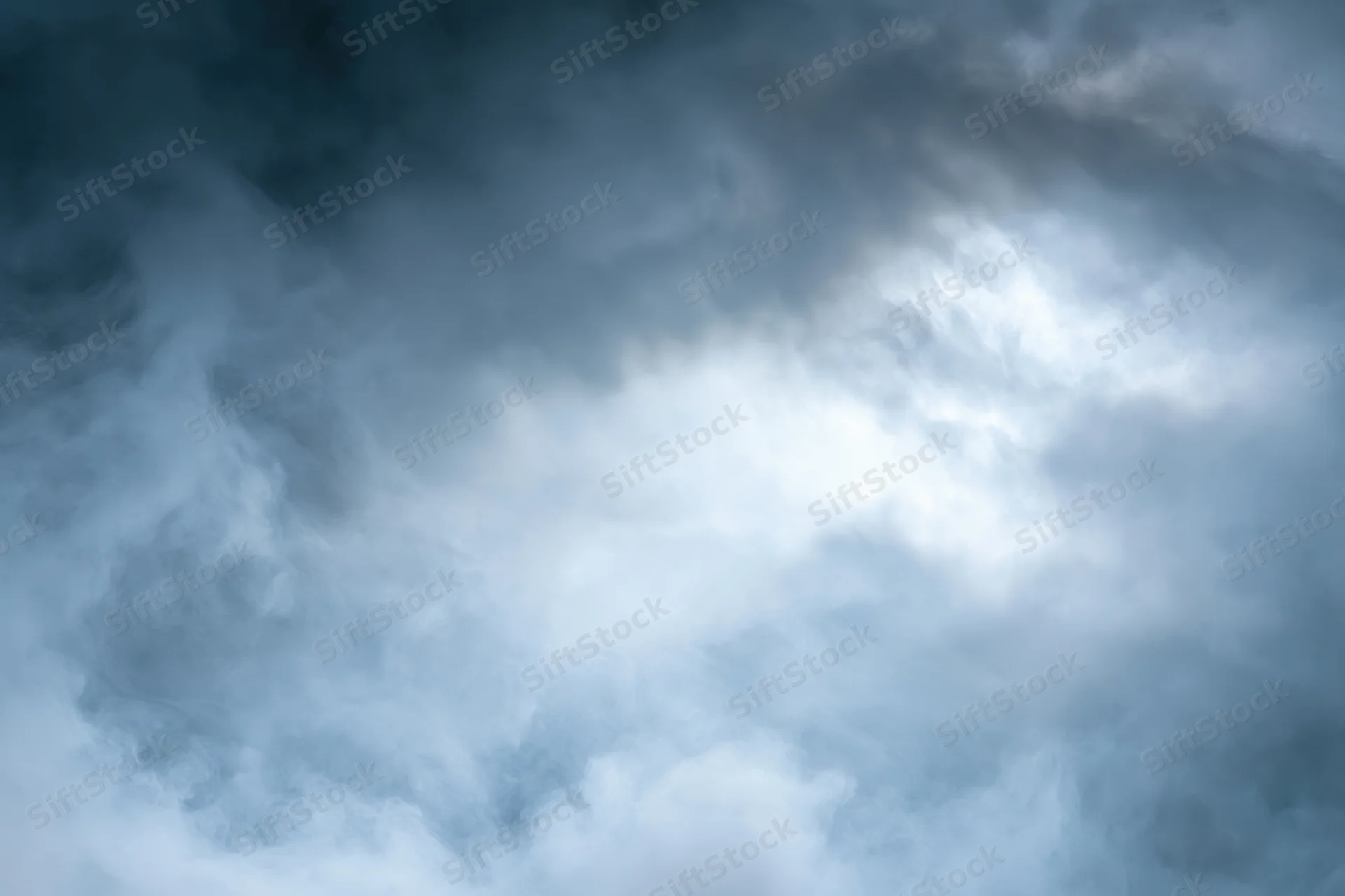 Dense billowing smoke filling the frame with swirling gray and white clouds against a dark blue sky