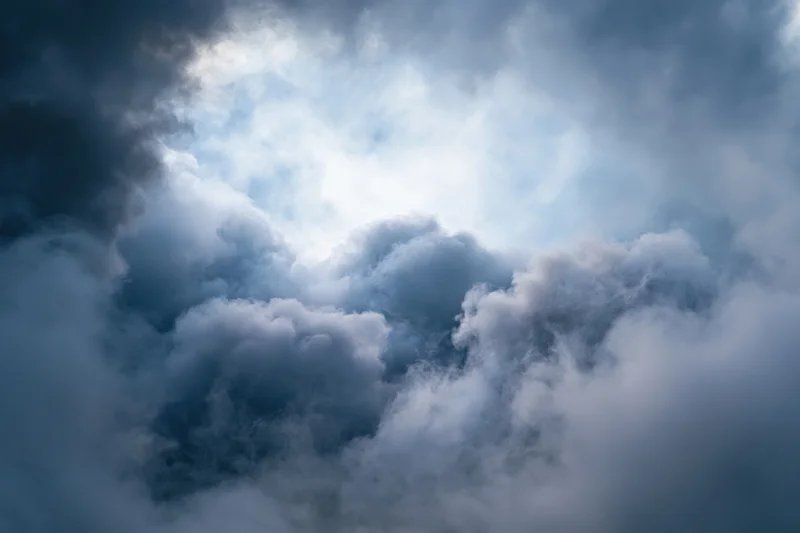 Dense billowing smoke filling the sky with dark and light clouds swirling in turbulent motion