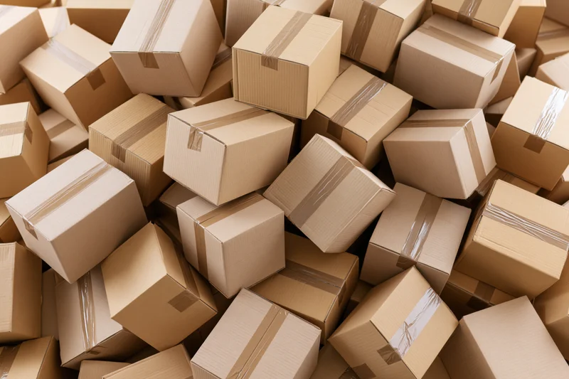 Cardboard boxes piled and scattered in a warehouse storage area