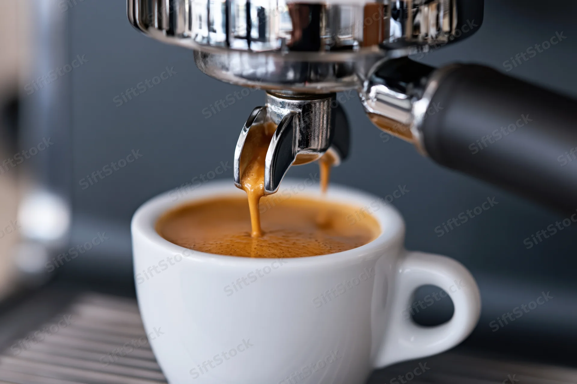 Espresso machine dispensing coffee into a white ceramic cup