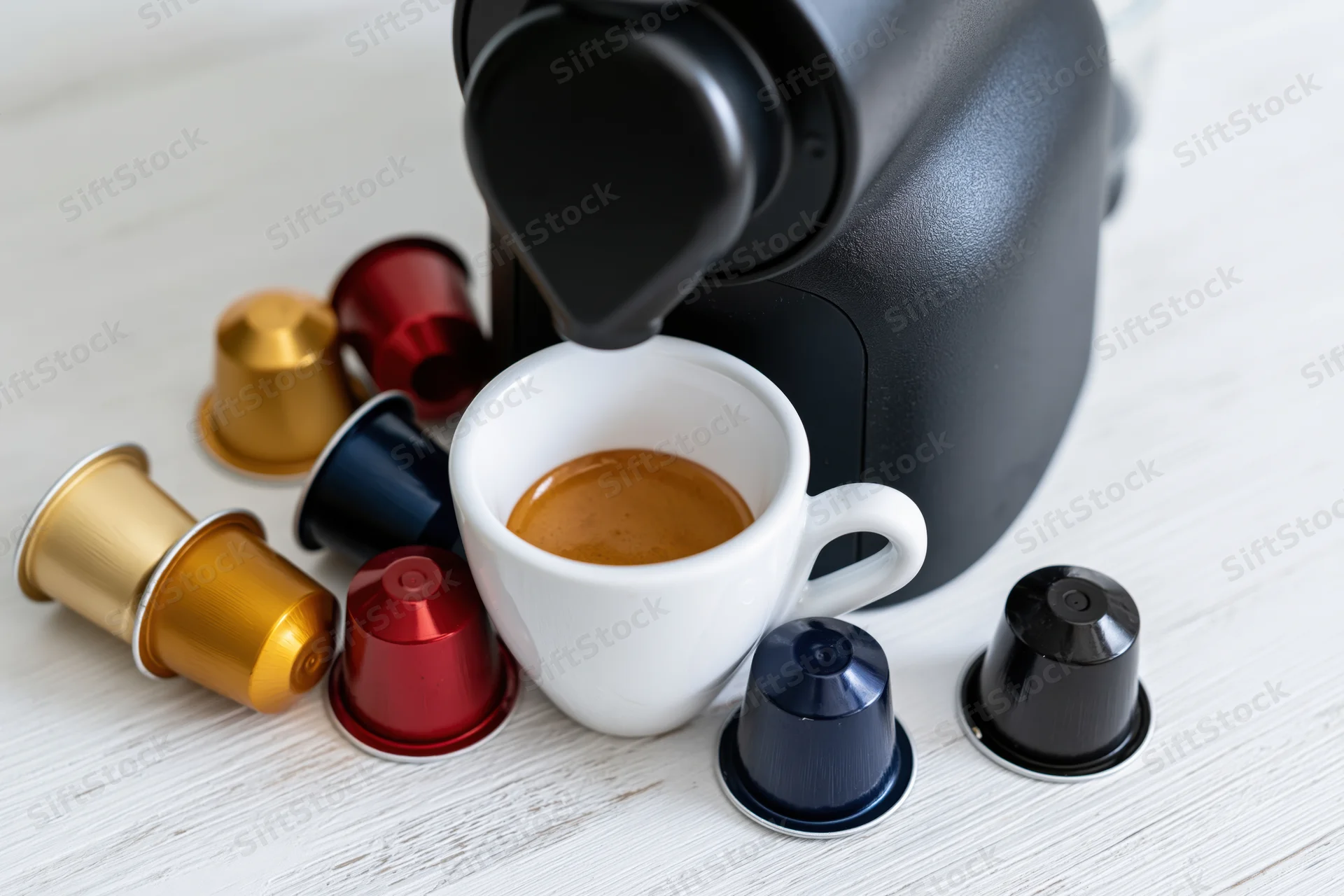 Espresso machine dispensing coffee into a white cup surrounded by colorful pods on a countertop