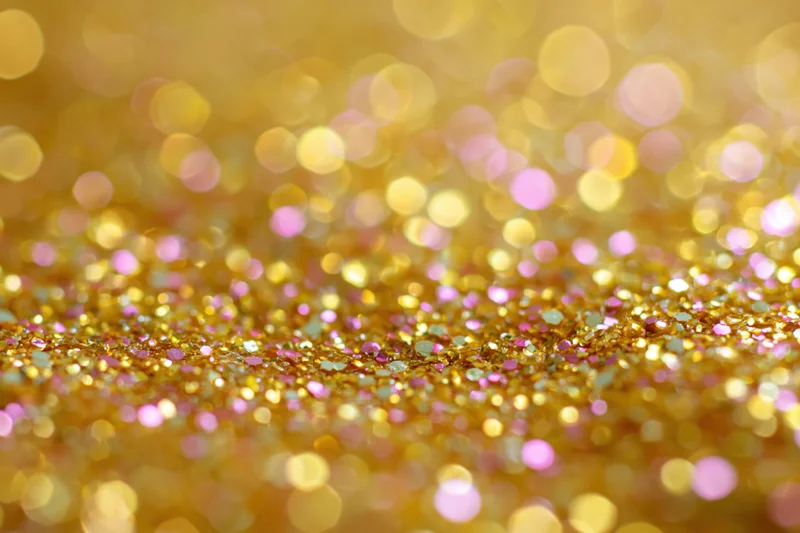 Close-up of gold and pink glitter surface with bokeh effect