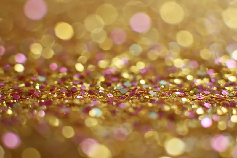 Close-up of gold and pink glitter surface with bokeh effect
