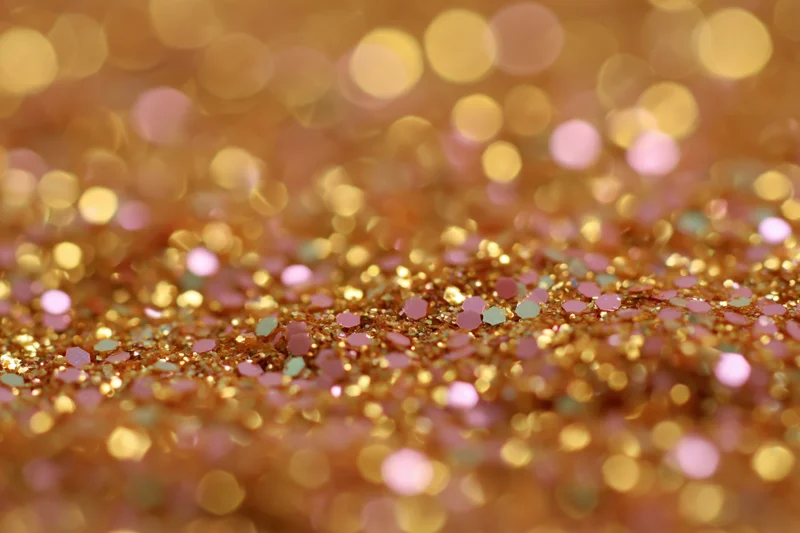 Close-up of gold and pink glitter surface with bokeh effect