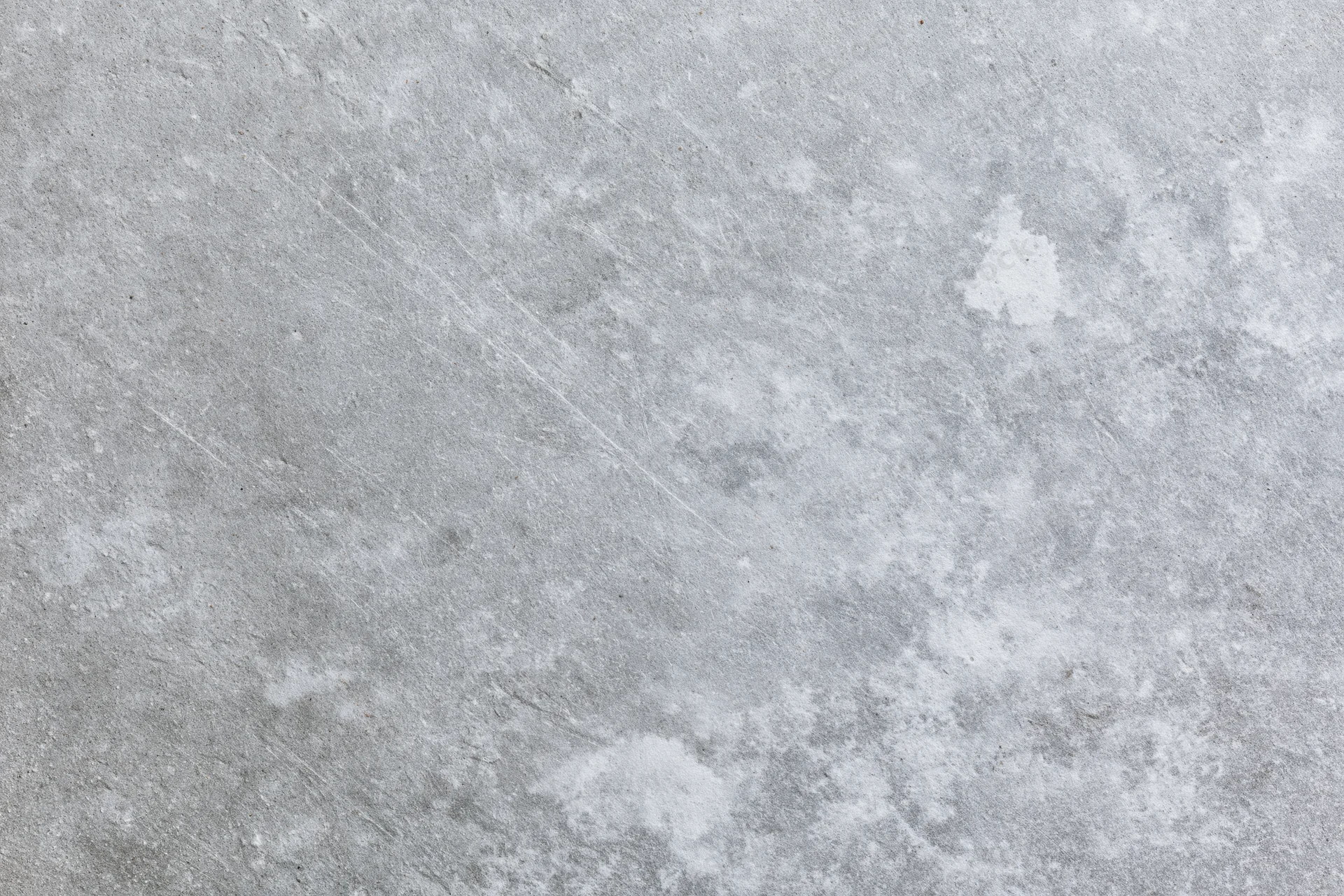 Flat gray concrete surface filling the frame with rough texture and weathered marks