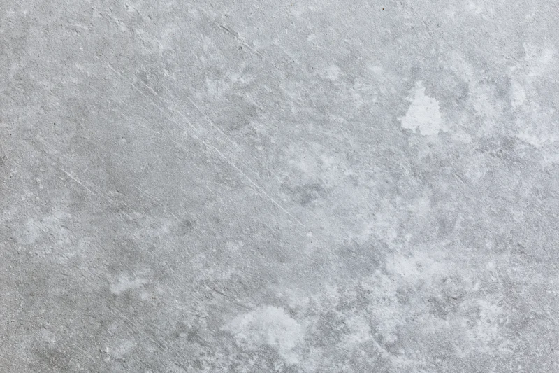 Flat gray concrete surface filling the frame with rough texture and weathered marks