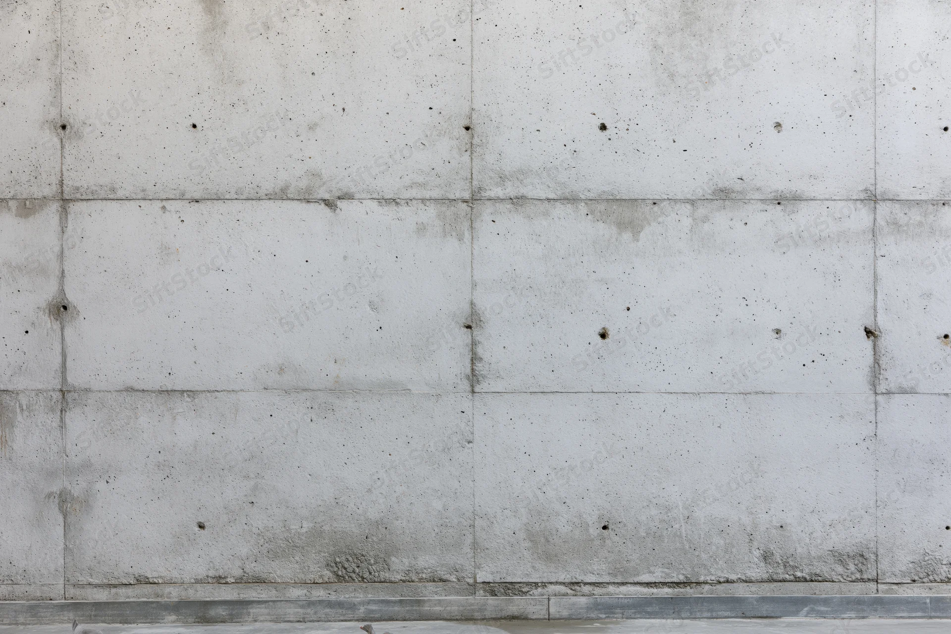 Flat concrete wall with visible seams and surface imperfections filling the frame