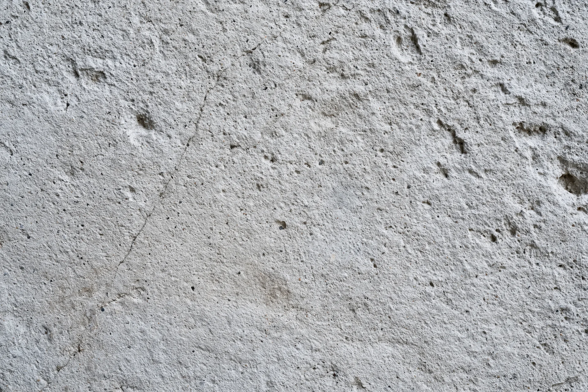 Close-up of a cracked gray concrete wall surface