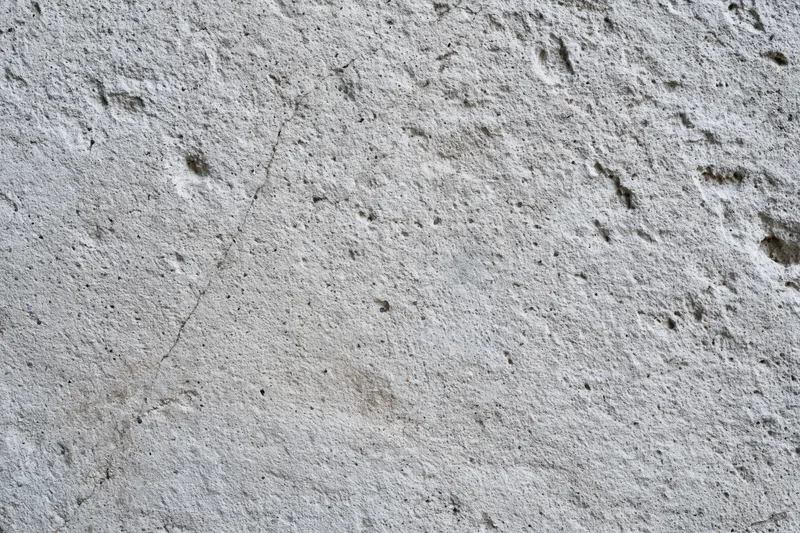 Close-up of a cracked gray concrete wall surface