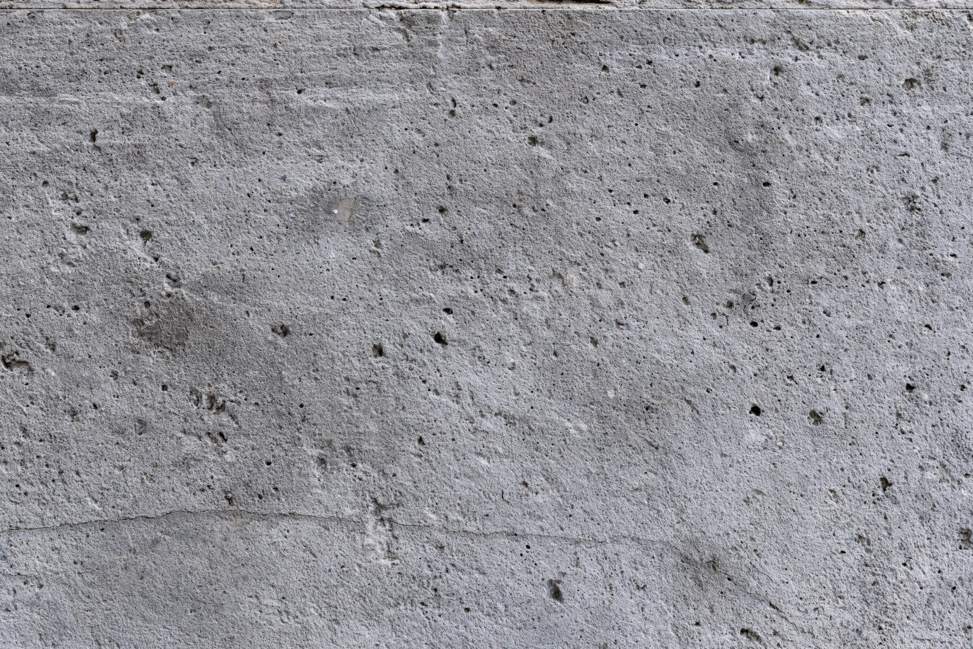 Close-up of a rough gray concrete wall surface filling the frame