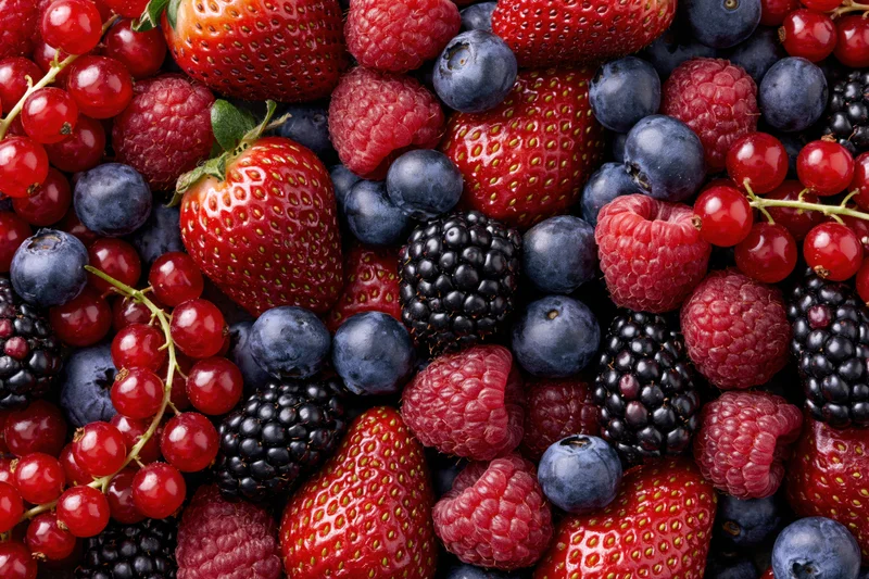 Mixed fresh berries arranged in a flat lay covering the entire frame