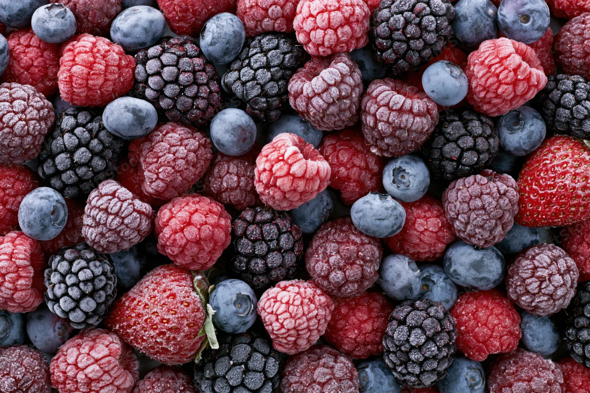 Frozen mixed berries covered in frost filling the frame