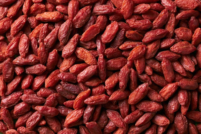 Dried goji berries filling the frame as a textured background with copyspace on the sides