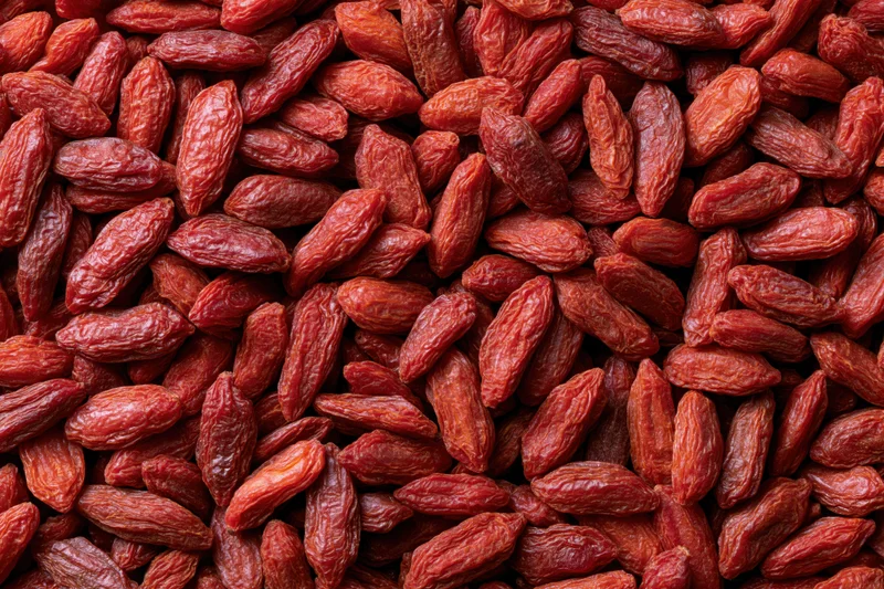 Dried goji berries filling the frame as a textured background with copyspace on the sides