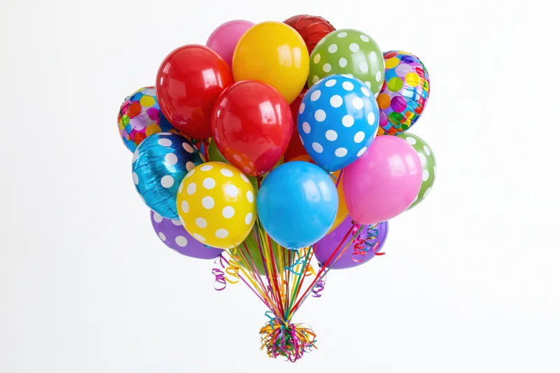 Colorful party balloons clustered together on white background