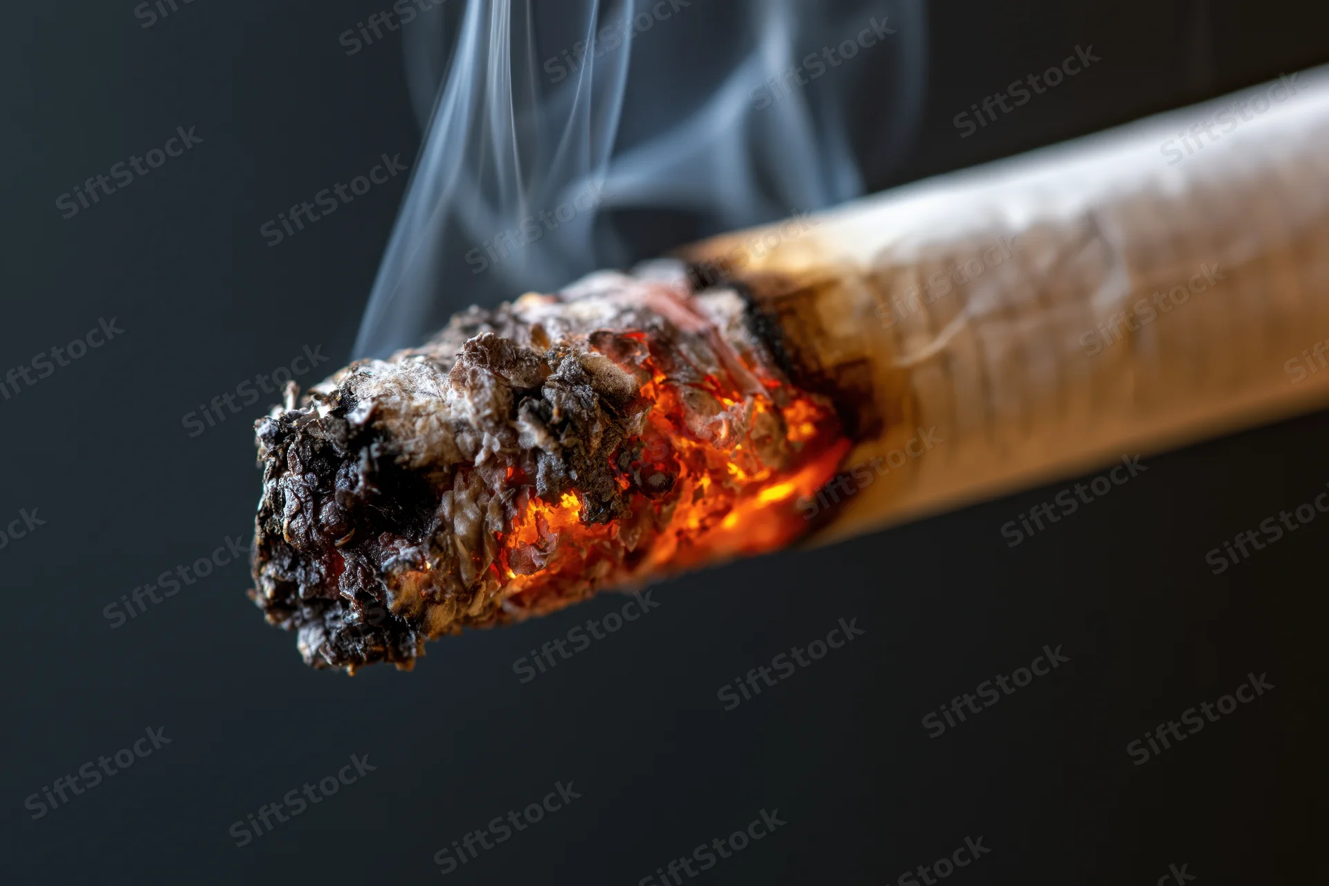 Burning cigarette tip with glowing ember and rising smoke against dark background