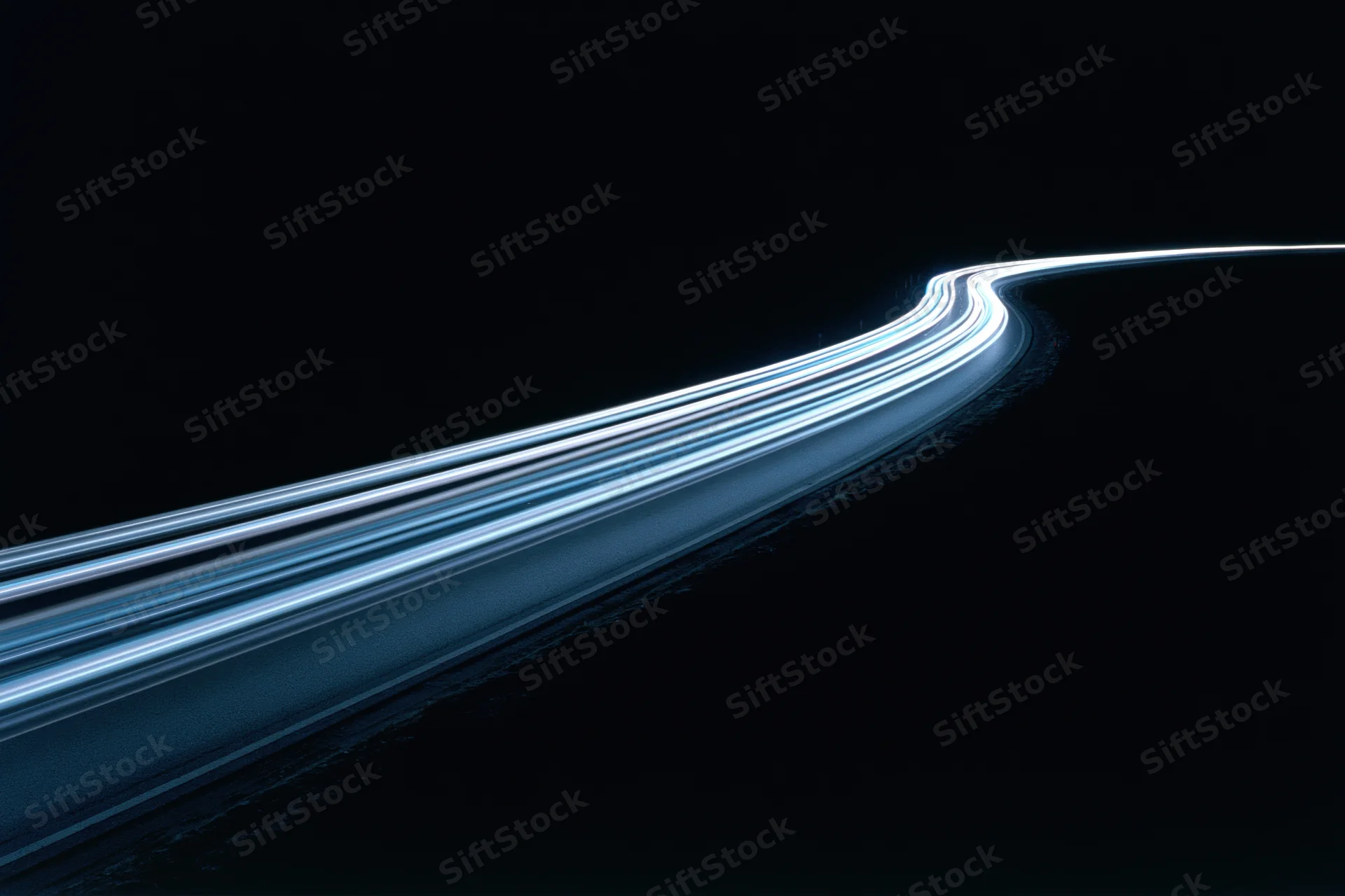 Long-exposure night highway with light trails curving through darkness