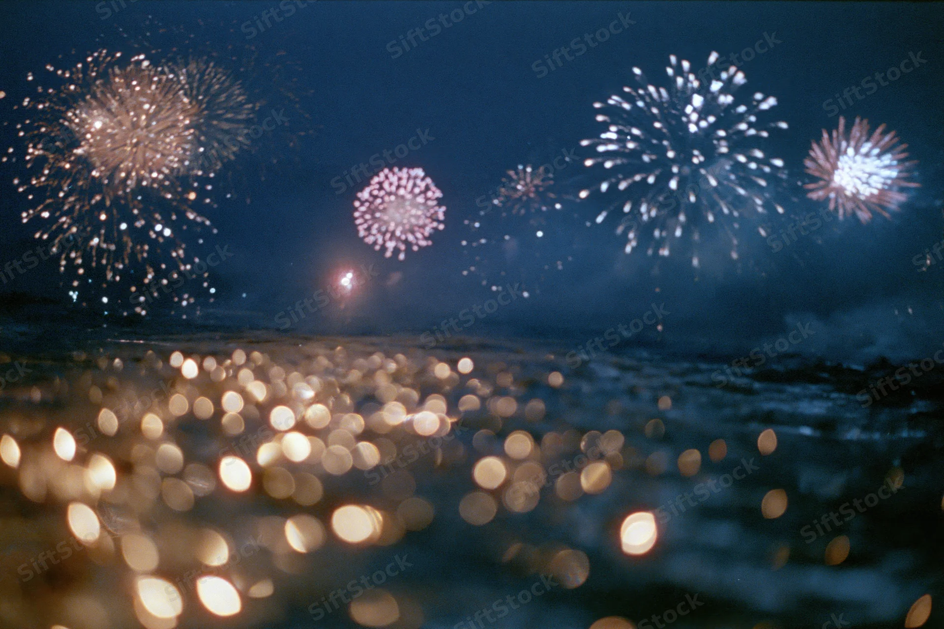 Fireworks bursting across dark night sky reflected in water with bokeh lights
