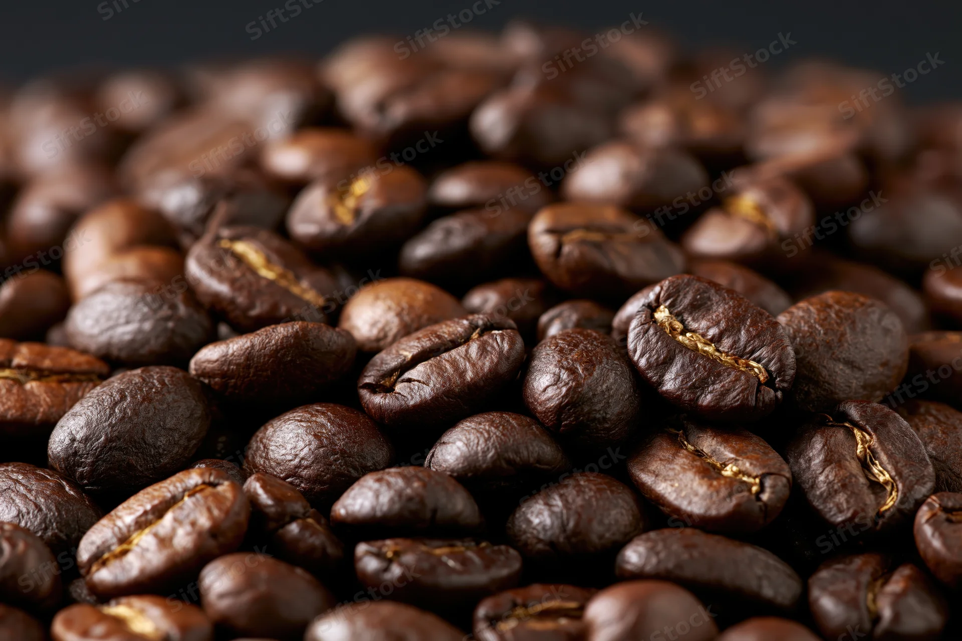 Closeup of roasted coffee beans piled together in a heap