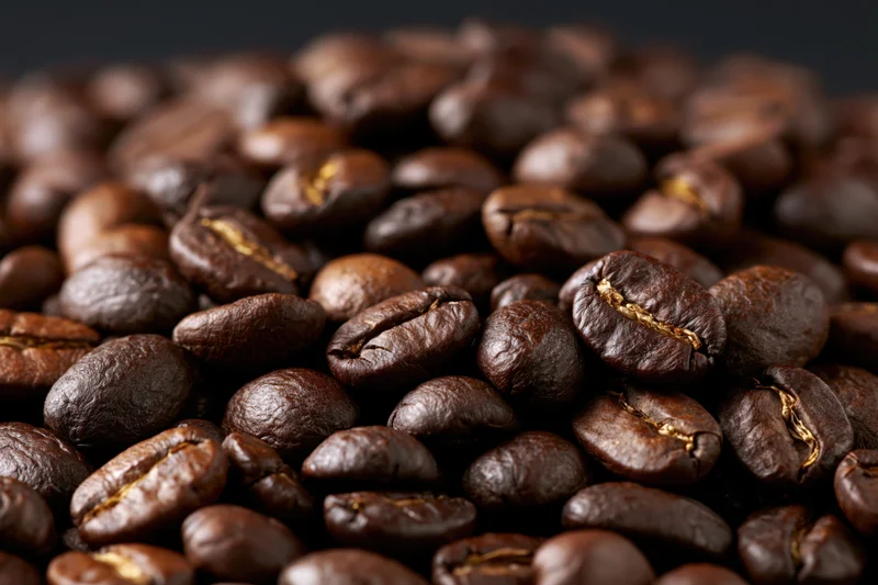 Closeup of roasted coffee beans piled together in a heap