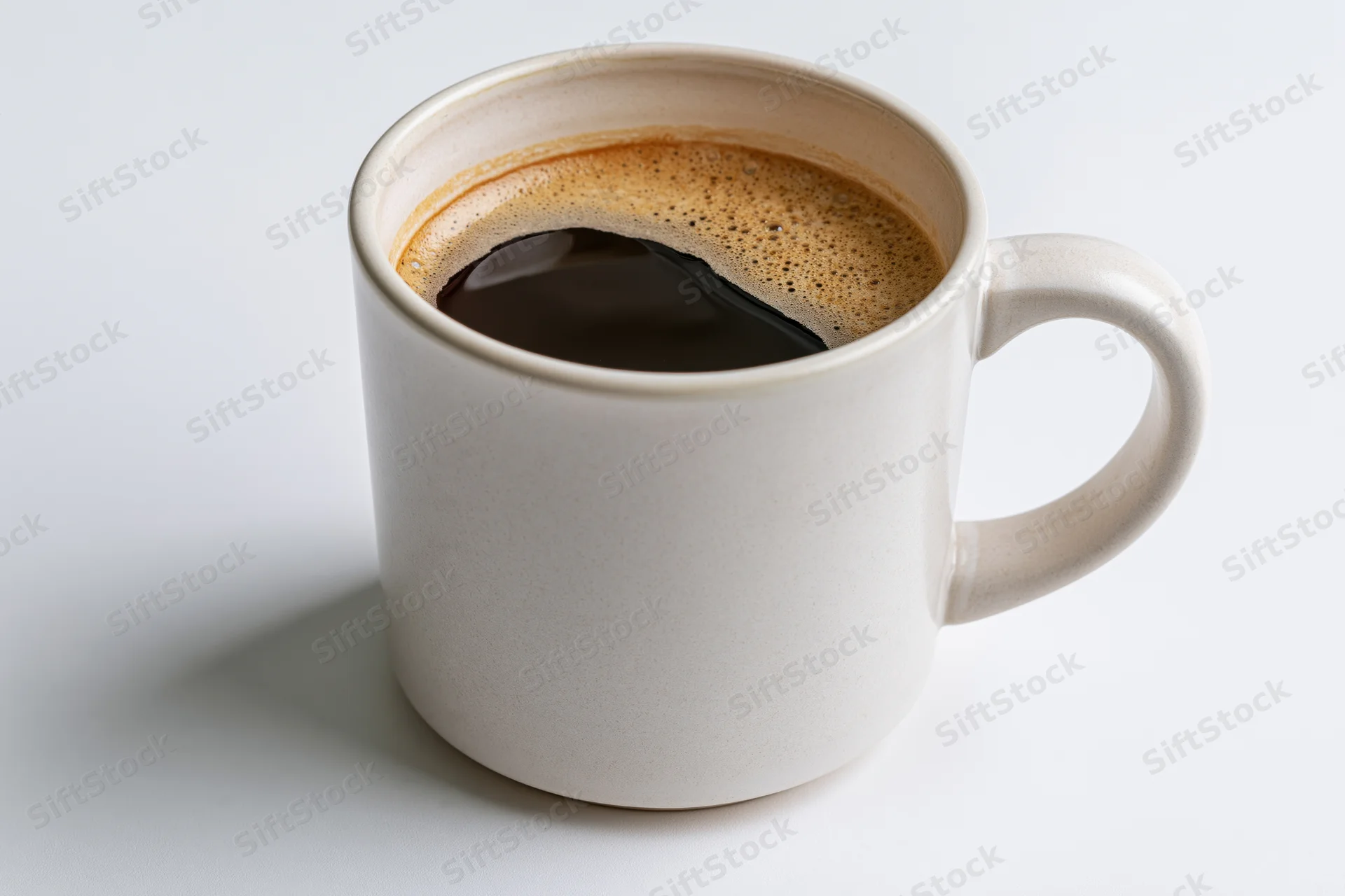 White ceramic mug filled with black coffee on plain white surface