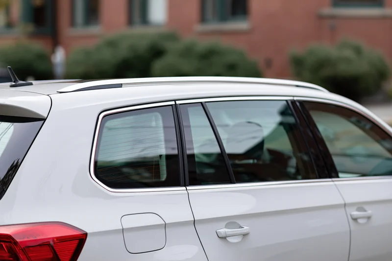 White suv parked on street shown in closeup side view with rear and windows visible