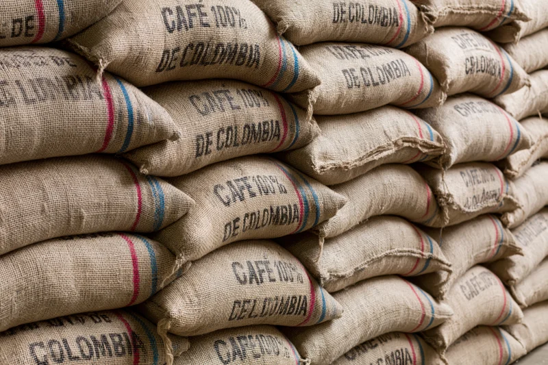 Rows of bulging burlap coffee sacks stacked floor to ceiling
