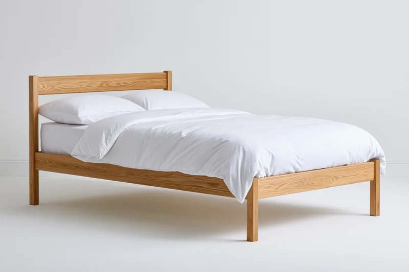 Solid oak bed frame with white bedding in a minimalist bedroom setting